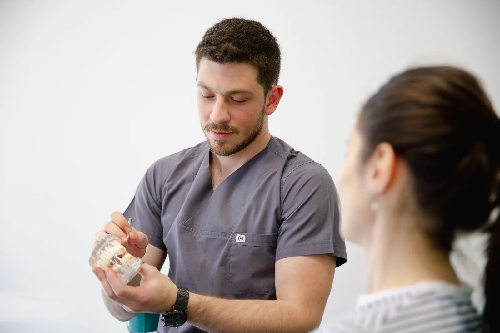 Dentist showing an implant model during a consultation, referred to in the Single Tooth Implant section for Winnipeg