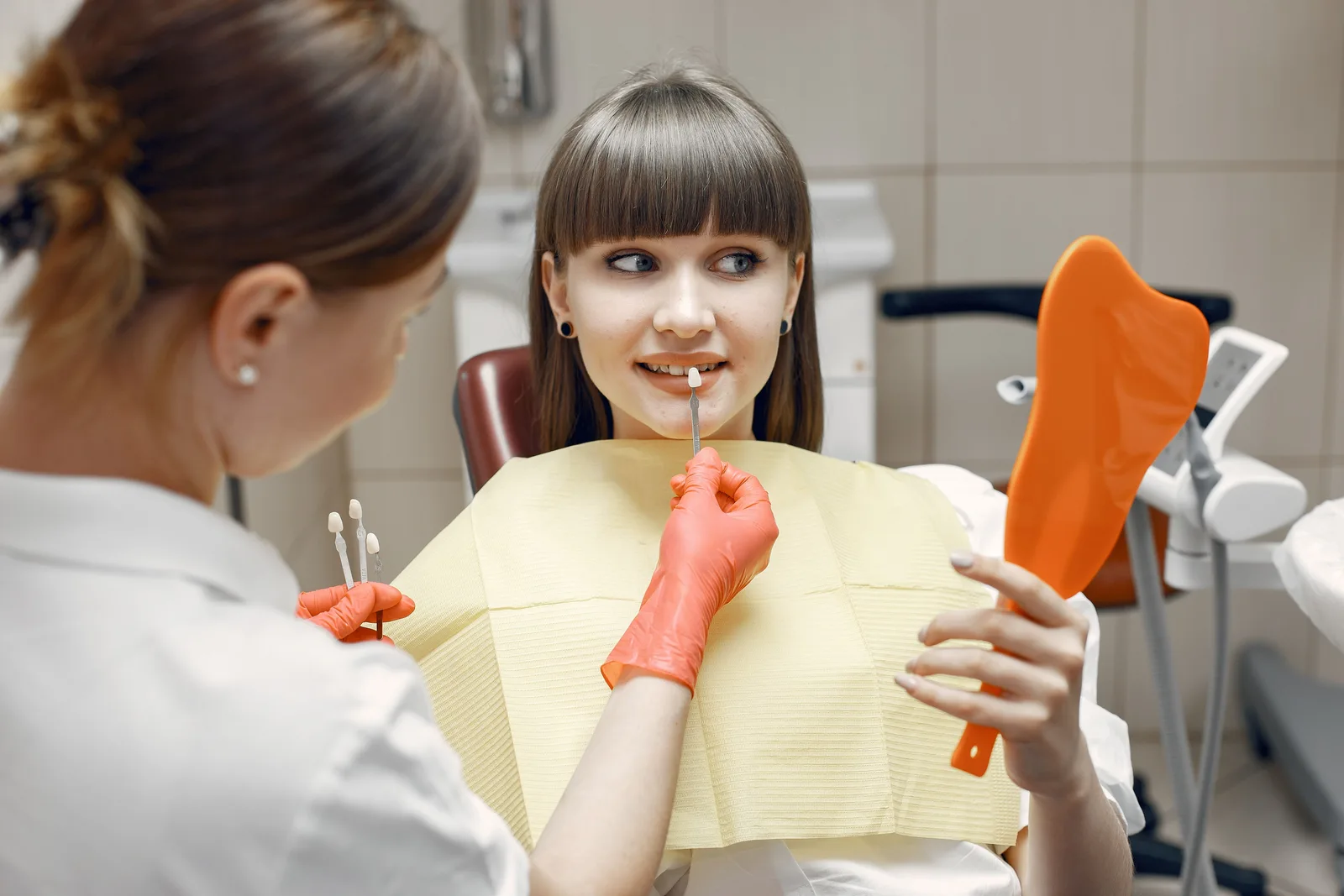 Patient checking crown shade in a hand mirror, alongside the Sinus Lift Surgery explanation in Winnipeg