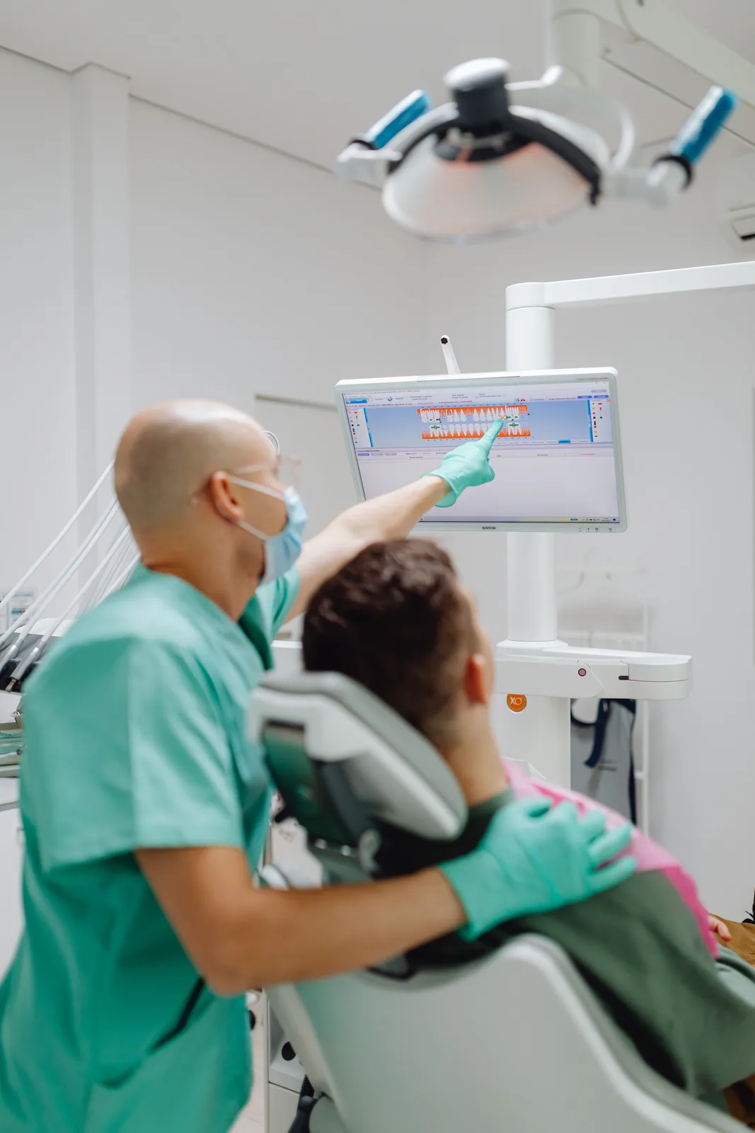 Reviewing the treatment plan on the chairside screen, alongside the Dentures Vs Implants explanation in Winnipeg